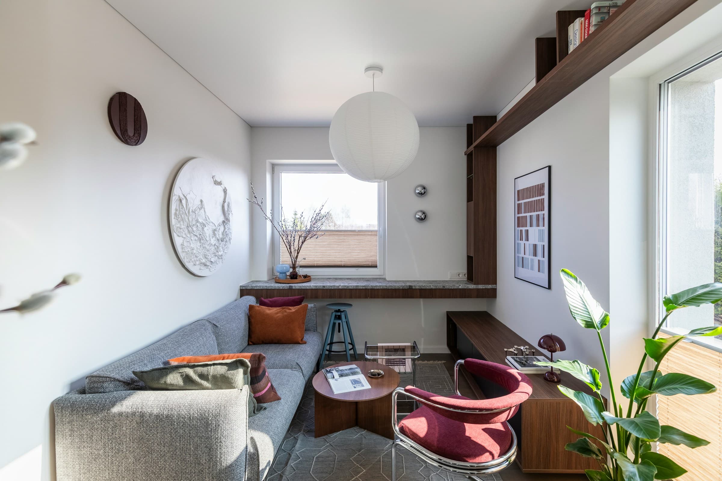 Bright compact living room with a long console below the window, a stool, and a calm neutral seating area