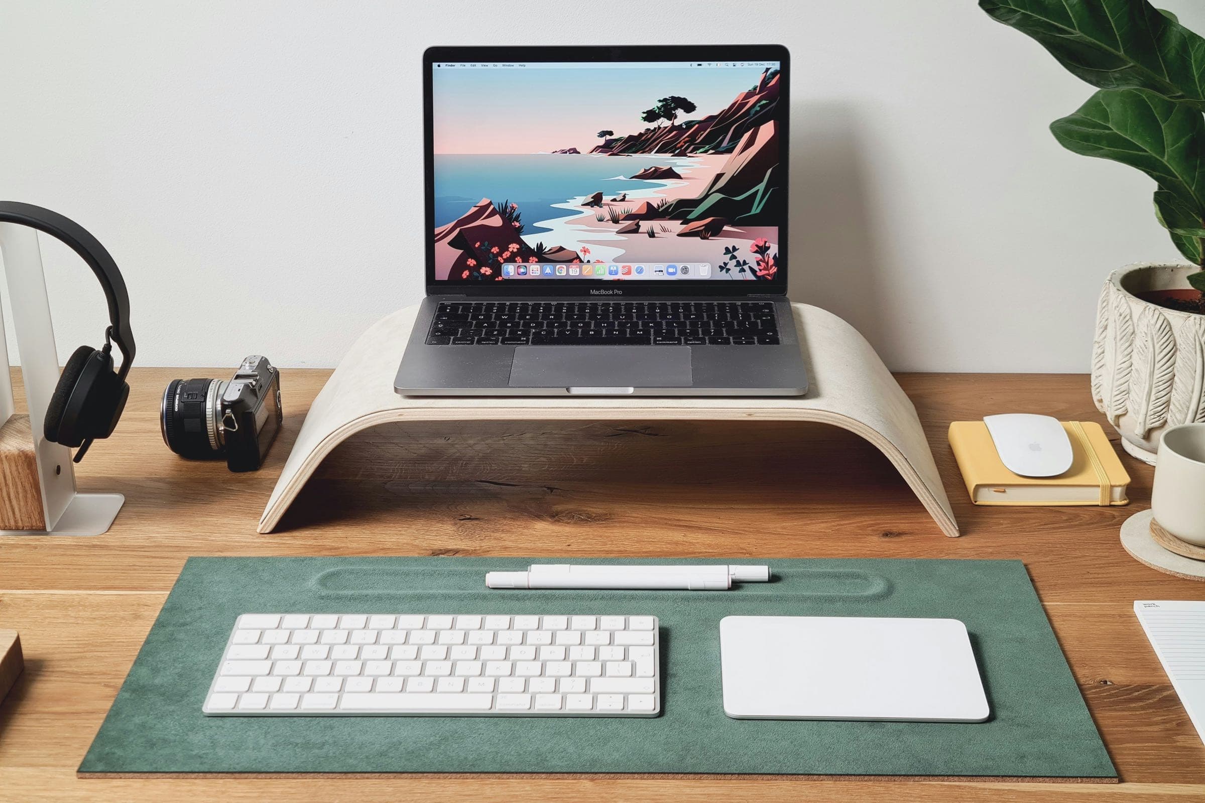 Poste de télétravail calme : ordinateur portable surélevé sur un support, avec un clavier et une souris séparés posés sur le bureau